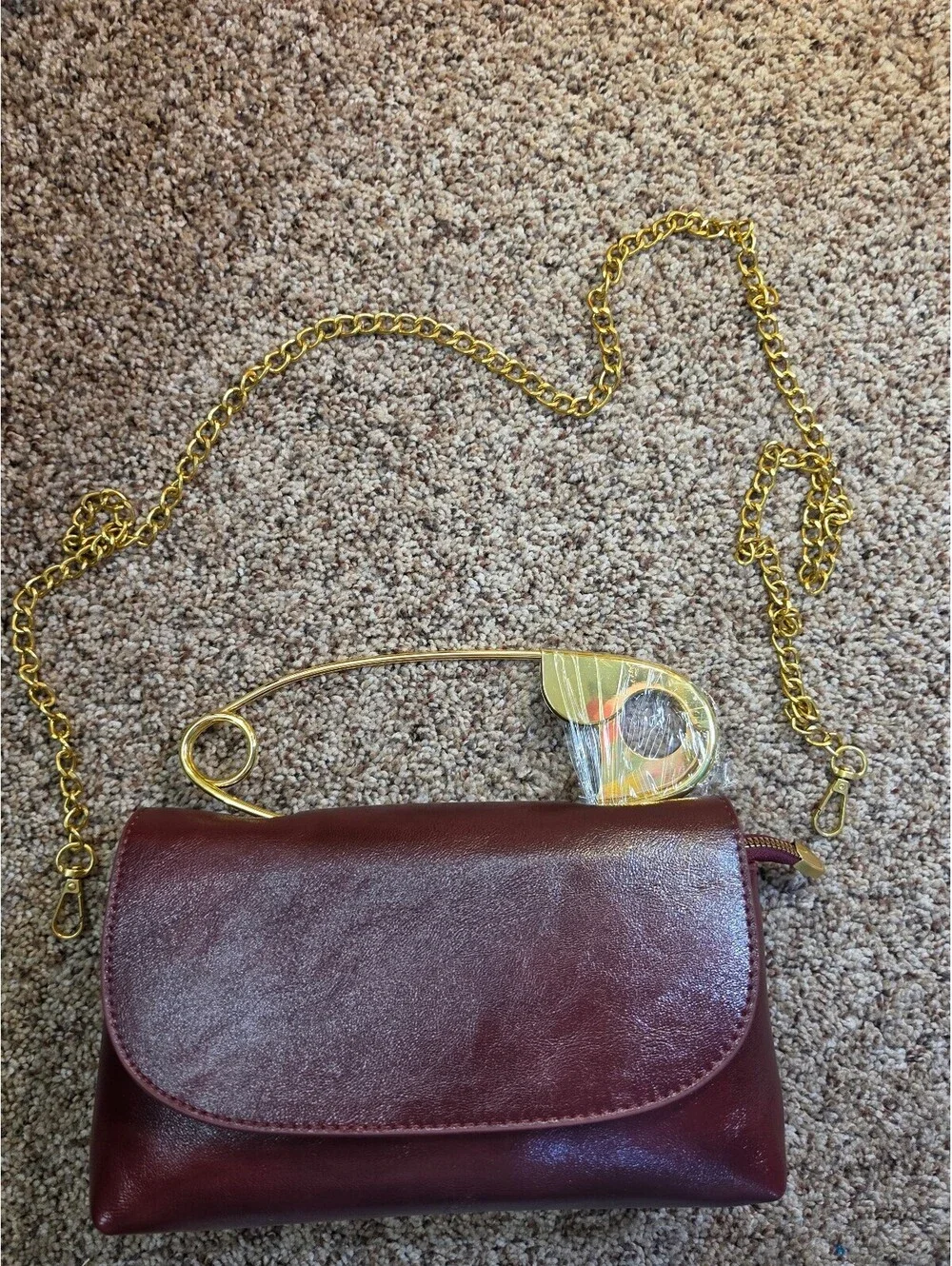 Elegant Burgundy Faux Leather Clutch Bag with Gold Chain and Safety Pin Detail